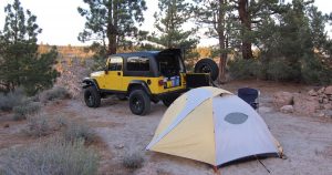 A yellow Jeep at a campground