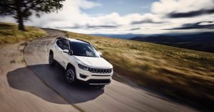 White 2019 Jeep Compass driving on a country road