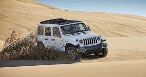 White 209 Jeep Wrangler off-roading in sand