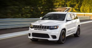 White Jeep Grand Cherokee driving down the road