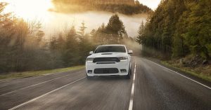 A white 2020 Dodge Durango driving down a forested street