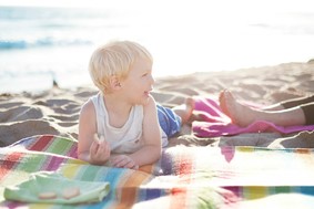 child on a blanket at the beach